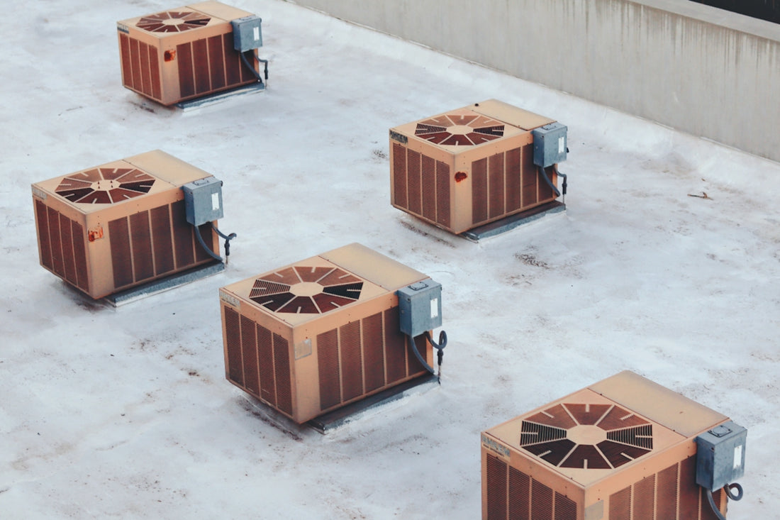 four air conditioners sitting on top of a snow covered ground